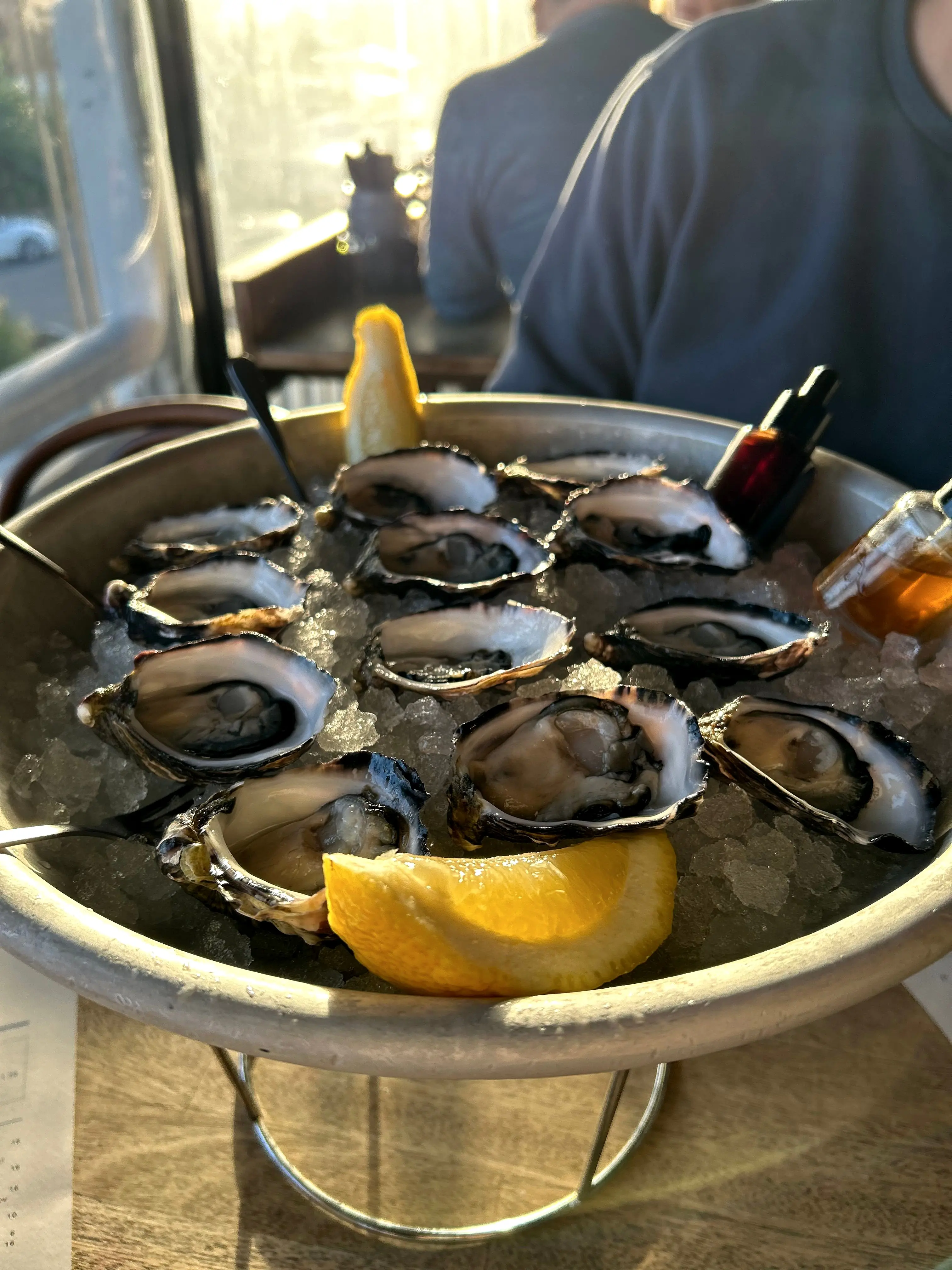 A tray of freshly shucked oysters on ice with a lemon wedge at Balcony Bar & Oyster Co. in Byron Bay
