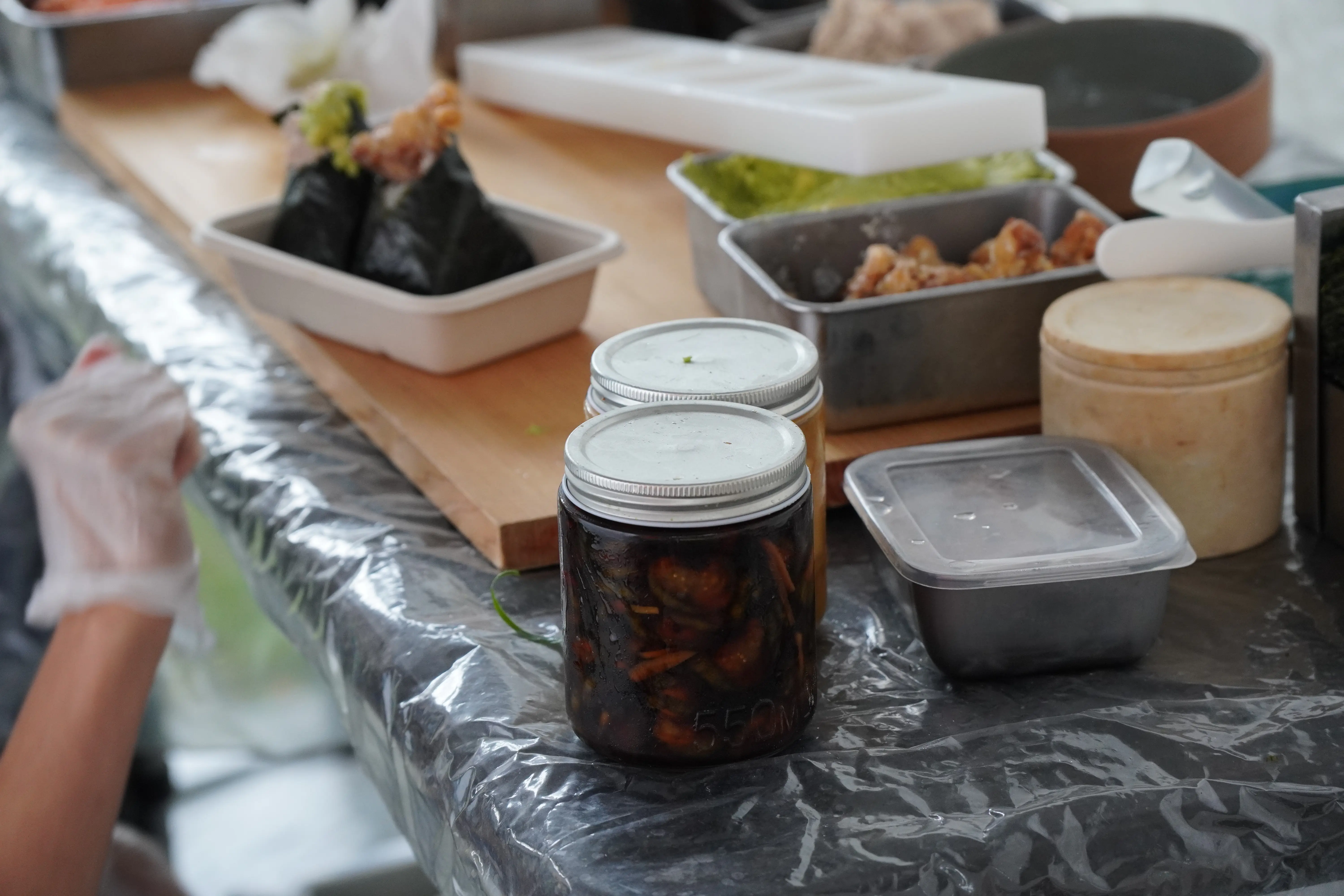 Pickle jars on a table in front of the cooking station