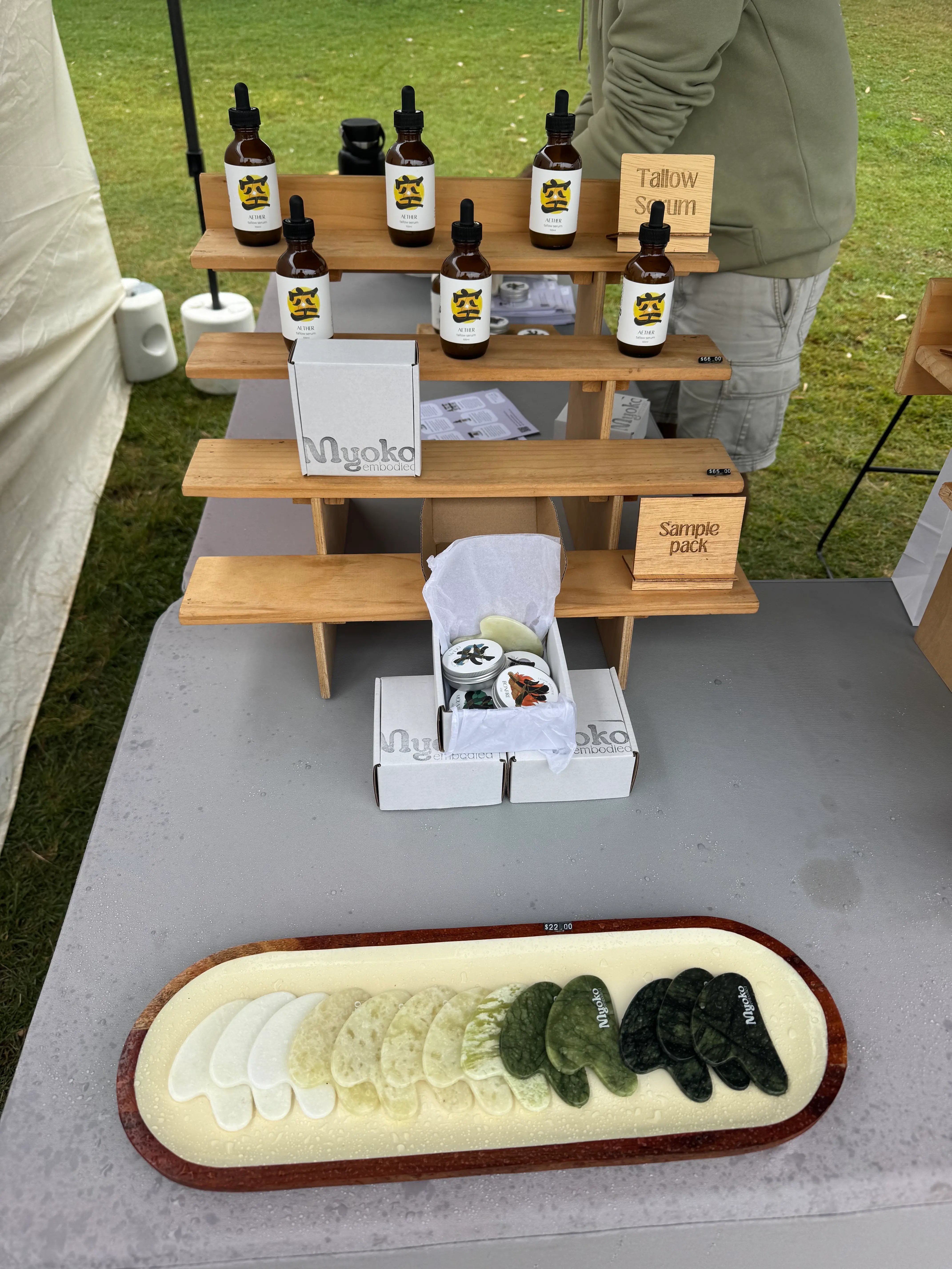 Myoko Embodied tallow skincare jars and sample products on display at the market stall