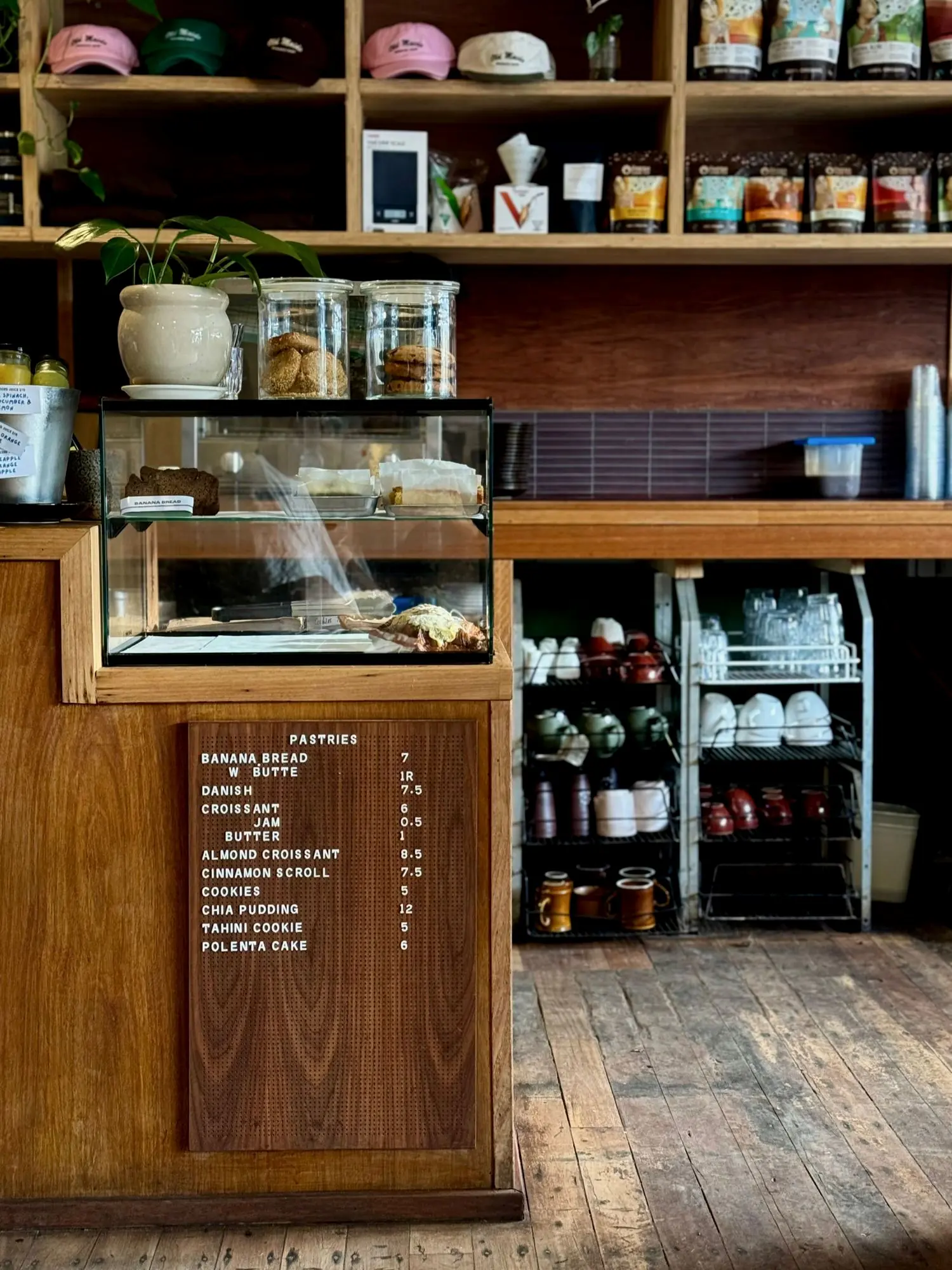 The timber counter at Old Maids in Brunswick Heads with a pastry cabinet and a hand-lettered pastries menu board