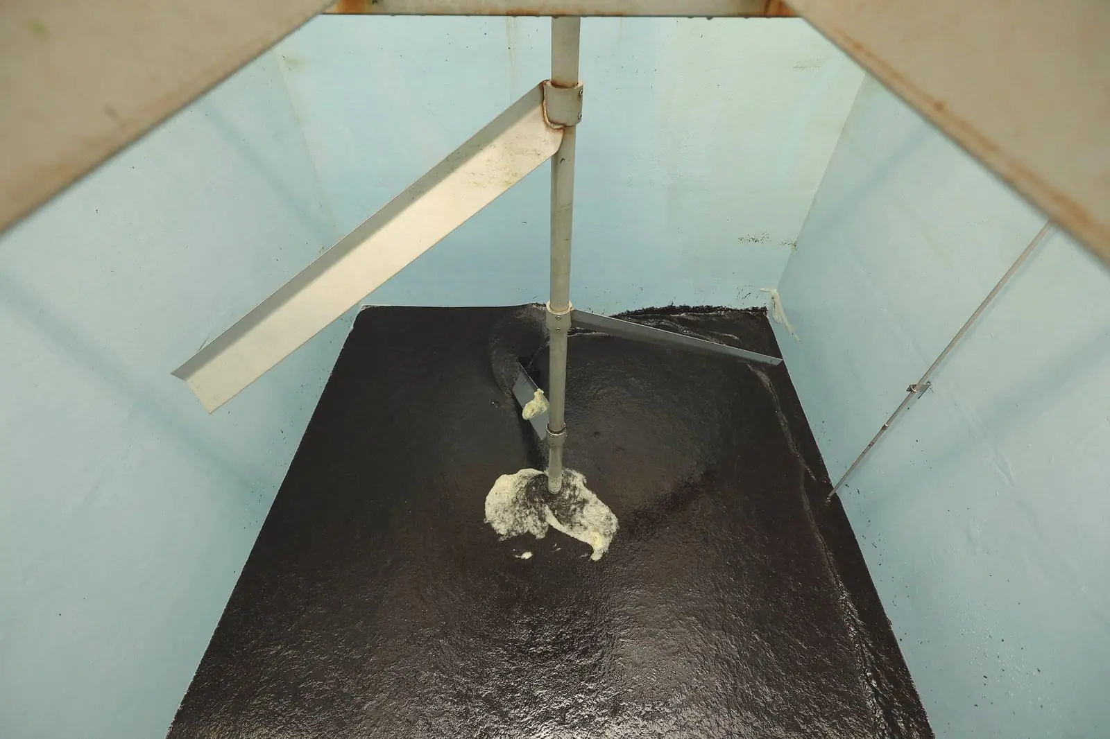 Chopped nori being stirred in a tank of water.